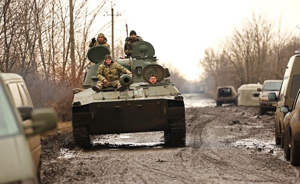 جنود أوكرانيون يستقلون دباباتهم قرب خط المواجهة في مدينة باخموت أمس	(رويترز)