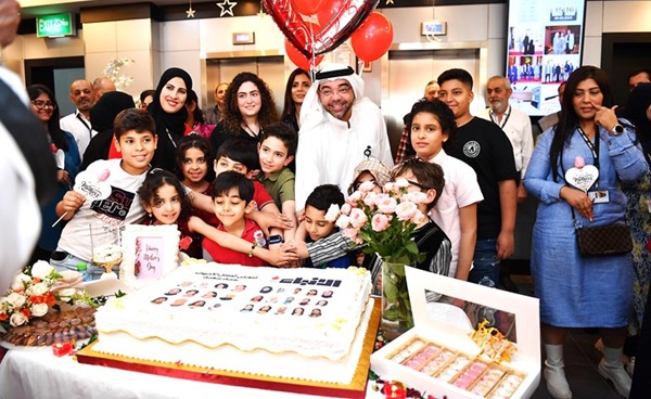 رئيس التحرير الزميل يوسف خالد المرزوق يقطع كيكة الحفل مع الأطفال