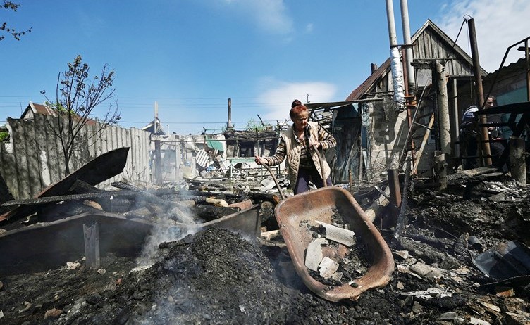 سيدة تزيل حطام منزل دمرته غارة عسكرية روسية في زابوريجيا	(رويترز)