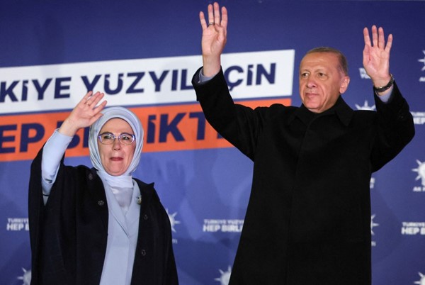  الرئيس التركي رجب طيب أردوغان وزوجته يلوحان لانصاره قبل القائه كلمة من مقر حزب العدالة والتنمية الحاكم في انقرة عقب النتائج الاولية للانتخابات الرئاسية ( رويترز) 