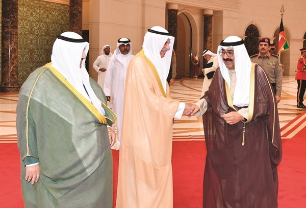 سمو ولي العهد الشيخ مشعل الأحمد مصافحا رئيس مجلس الأمة أحمد السعدون بحضور سمو الشيخ ناصر المحمد