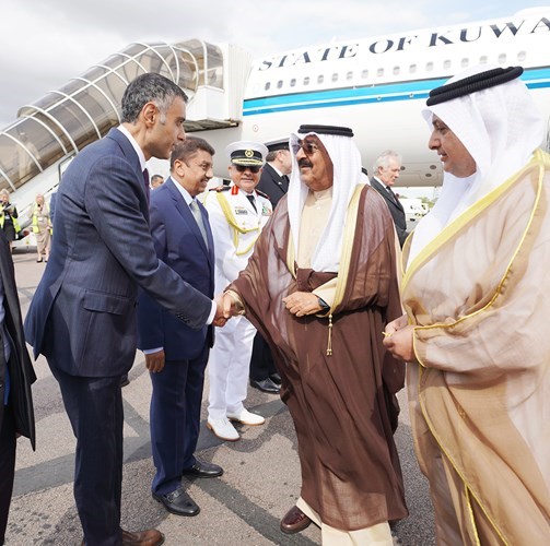 سمو ولي العهد مصافحا أحد مستقبليه بحضور السفير بدر العوضي وغانم الغنيمان