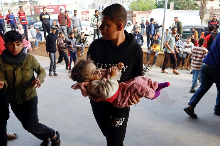 إسعاف طفل فلسطيني إلى مستشفى ناصر بعد إصابته في غارة إسرائيلية على غزة (رويترز)