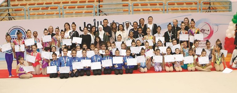 فاطمة حيات وفهد الصولة مع اللاعبات المشاركات في مهرجان الجمباز