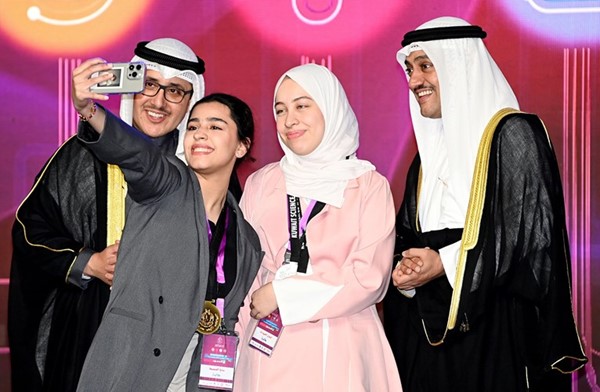 إحدى الطالبات تلتقط سيلفي مع الشيخ د. أحمد الناصر وطلال الخرافي