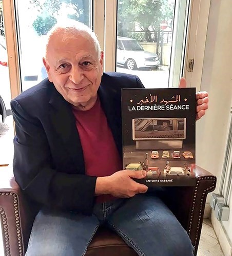 أنطوان كبابه حاملا كتابه المشهد الأخير