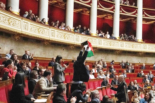   النائب عن حزب «فرنسا الأبية» سيباستيان ديلوغو ملوحاً بعلم فلسطين خلال جلسة الجمعية الوطنية (ا.ف.پ)