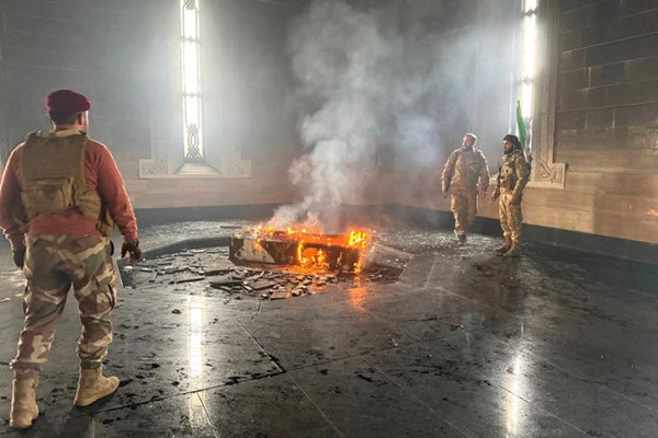 مقاتلو المعارضة لدى إحراق قبر الرئيس الأسبق حافظ الأسد في مسقط رأسه بالقرداحة	 (أ.ف.پ)