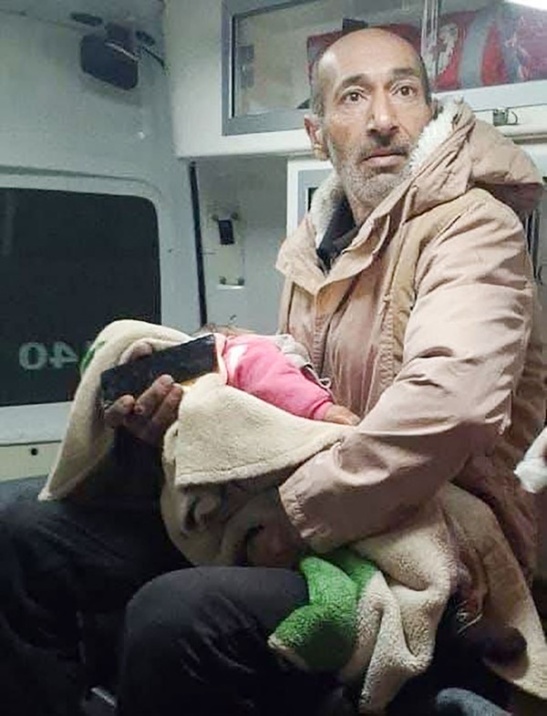 والد الطفلة ساجدة حسن شموطي يحملها في سيارة الإسعاف بعد أن توفيت جراء إصابتها برصاص طائش من احتفالات السنة الجديدة (محمود الطويل)