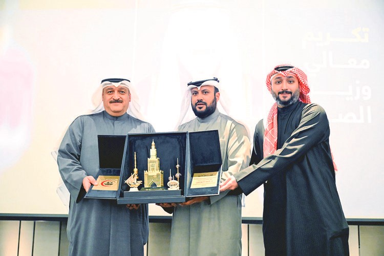 د.أحمد العوضي يتسلم درعا تكريمية من د.إبراهيم الطوالة