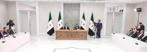صورة تلفزيونية للرئيس السوري أحمد الشرع لدى التوقيع على الإعلان الدستوري