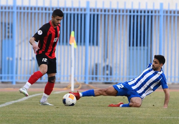 لاعب الشباب علي جوهر يوقف الكرة بقدمه في مواجهة لاعب خيطان محمد الموسوي