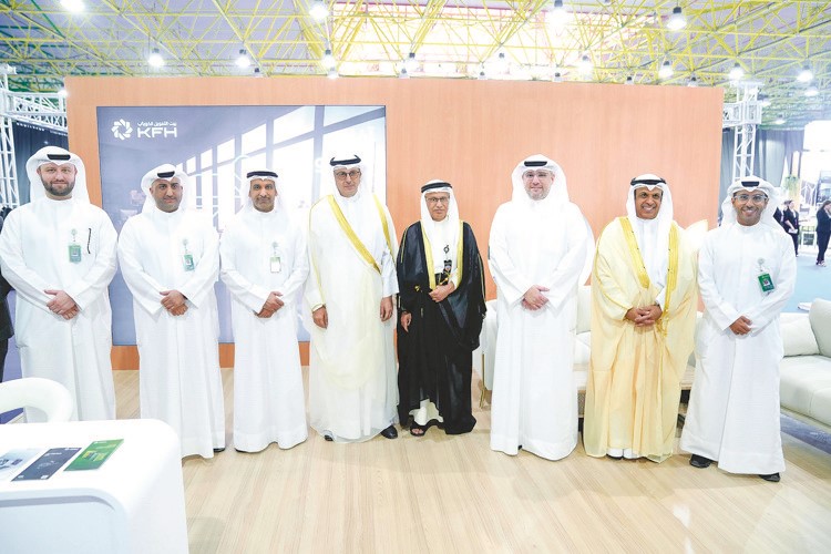 د.صبيح المخيزيم ويوسف الرويح في لقطة جماعية مع عدد من المسؤولين وموظفي البنك داخل جناح بيت التمويل الكويتي المشارك في المعرض
