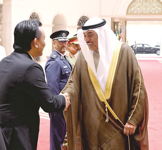 ممثل صاحب السمو الأمير الشيخ مشعل الأحمد سمو ولي العهد الشيخ صباح الخالد مصافحا سفير ماليزيا علاء الدين بن محمد نور