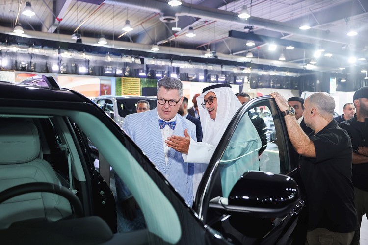 طلال بهبهاني وستيفن باتلر خلال استعراضهم طرازات جي ام سي المشاركة في المعرض