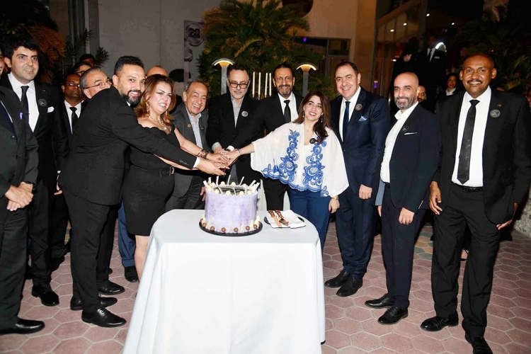 محمد ناجيا مشاركا في قطع كعكة الاحتفال بحضور مسؤولي فندق هوليداي إن السالمية