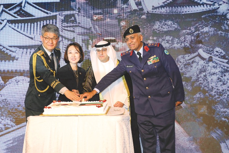وزير الدولة لشؤون البلدية ووزير الدولة لشؤون الإسكان عبداللطيف المشاري والقائم بالأعمال في سفارة كوريا المستشارة كيم هيجين وممثل وزارة الدفاع آمر سلاح الدفاع الجوي العميد الركن فراس القطان خلال قطع كيكة الاحتفال بعيد القوات المسلحة الكورية