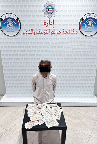 المتهمون وأمامهم المضبوطات من العملات المزيفة