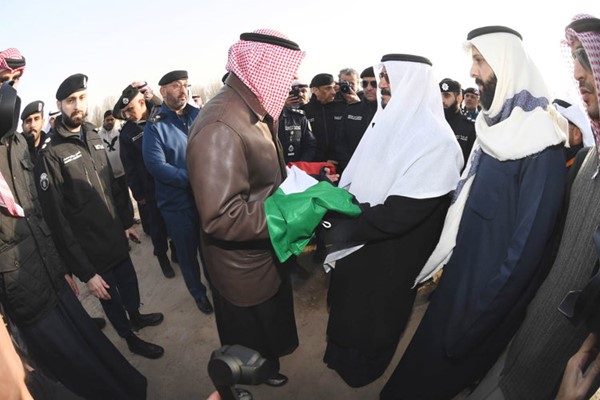 النائب الأول لرئيس مجلس الوزراء ووزير الداخلية الشيخ فهد اليوسف يسلم سعد الهاجري والد شهيد الواجب رقيب محمد سعد الهاجري علم الكويت