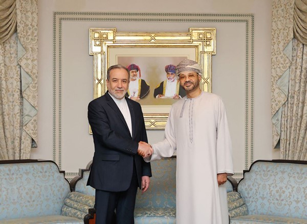 وزير الخارجية العماني بدر بن حمد البوسعيدي مستقبلا نظيره الإيراني عباس عراقجي في مسقط على هامش المحادثات غير المباشرة بين طهران وواشنطن ( ا.ف.پ)