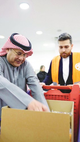 رئيس قسم المبيعات في شركة مطاحن الدقيق والمخابز الكويتية نبيل الجحيل يجهز السلال الغذائية مع موظفي طلبات