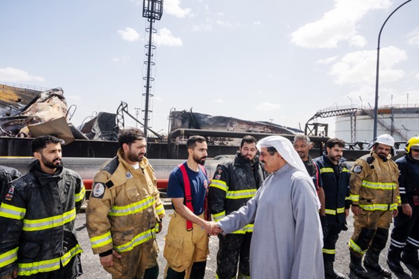 سمو الشيخ أحمد العبدالله رئيس مجلس الوزراء مصافحا الطواقم المشاركة في إخماد حريق خزانات الوقود