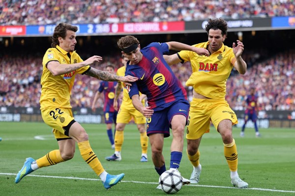 لاعب وسط برشلونة فيرمين لوبيز محاولا تخطي لاعبي إسبانيول كارلوس لوميرو ولياندرو كابريرا