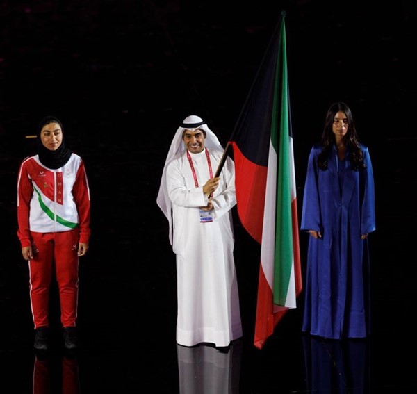 لاعب منتخبنا الوطني للرماية خالد المضف حاملاً علم الكويت إلى جانب الفارسة يارا الهنيدي في حفل الافتتاح