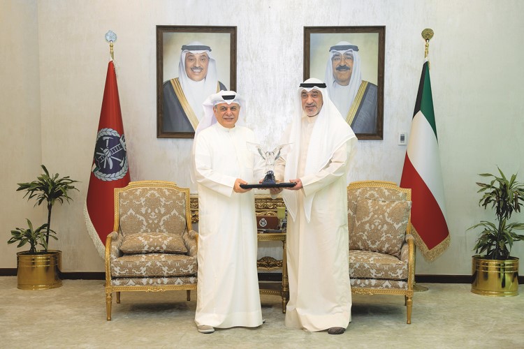 النائب الأول لرئيس مجلس الوزراء ووزير الداخلية الشيخ فهد اليوسف يتسلم درعا تكريمية من عادل الماجد