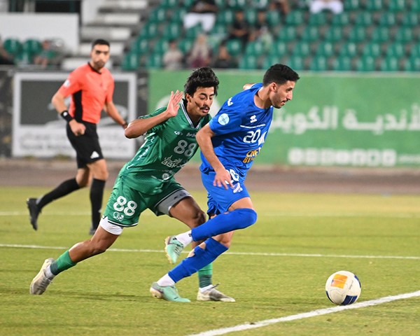 لاعب التضامن حسن حسون يتقدم بالكرة بمضايقة من لاعب العربي عبدالله القرزعي
