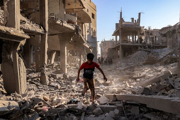 طفل فلسطيني يسير وسط مبان دمرتها غارة اسرائيلية على مخيم المغازي وسط قطاع غزة    ( ا.ف.ب)