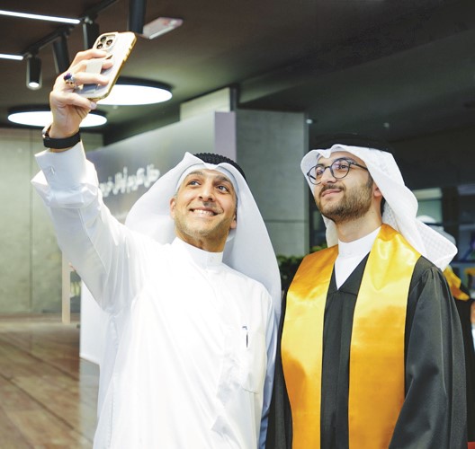 أحد الخريجين محتفلا مع أحد أفراد عائلته