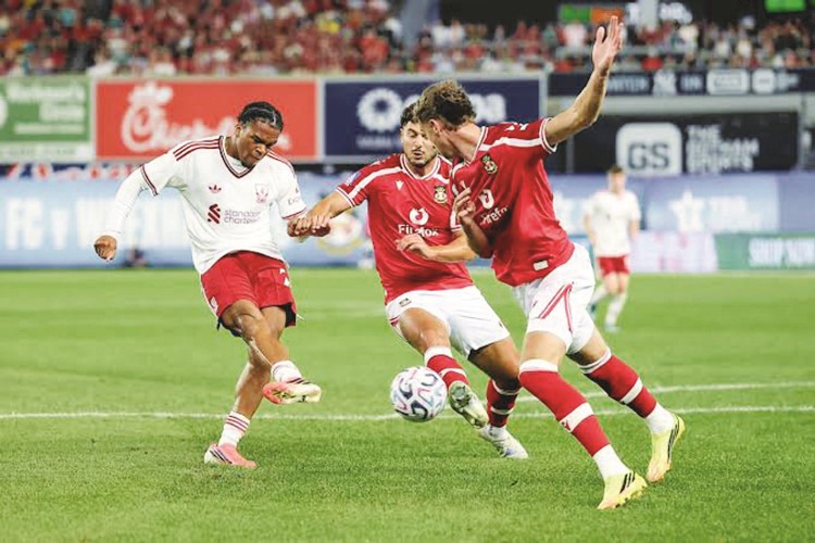 لاعب ليڤربول ريو نغوموها يسدد على مرمى وريكسم الويلزي