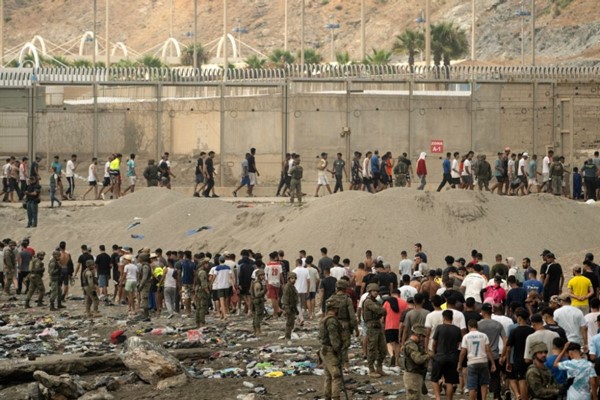  جنود إسبان يراقبون عملية عودة المهاجرين إلى المغرب وذلك بعد عبورهم الحدود لدخول جيب سبتة الإسباني شمال أفريقيا (أ.ف.پ)