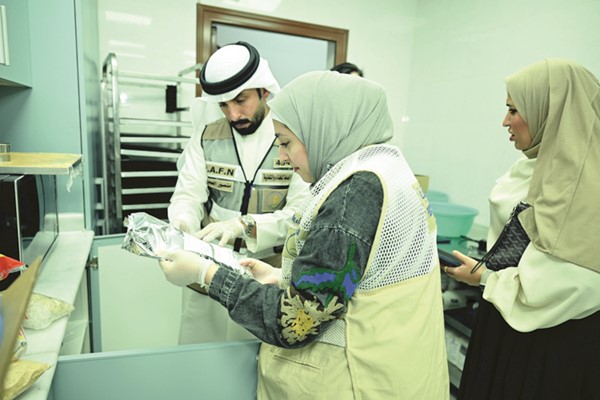 مراقب تفتيش الأغذية بإدارة تفتيش محافظة مبارك الكبير في الهيئة العامة للغذاء والتغذية حنان عباس حسين تدقق على صلاحية المنتجات الغذائية			(قاسم باشا)