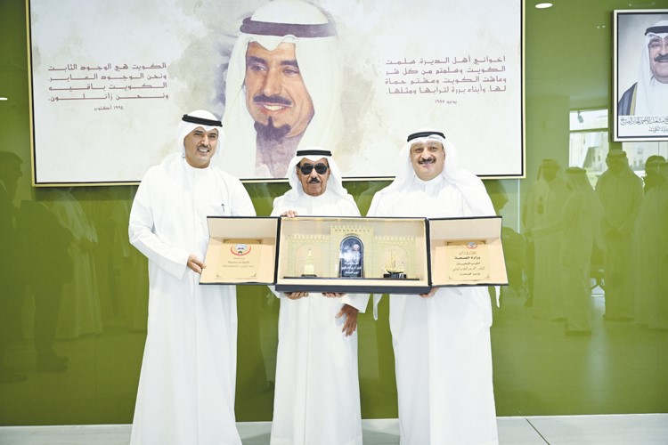 الشيخ مبارك الجابر يتسلم التكريم من د.أحمد العوضي والشيخ حمود الجابر