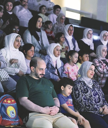 الأطفال مع ذويهم يتابعون العرض
