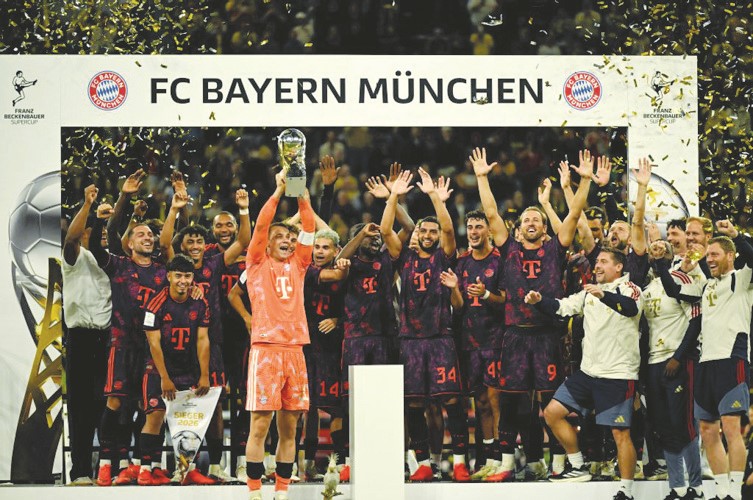 قائد بايرن ميونيخ مانويل نوير يرفع كأس السوبر الألماني