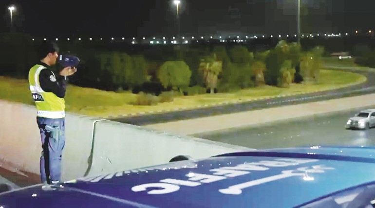 أحد رجال المرور يوثق مخالفات التجاوز من أعلى الجسر