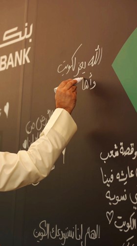 موظفو بنك برقان يوقعون على جدار الإهداء في المقر الرئيسي للبنك