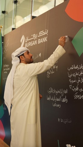 موظفو بنك برقان يوقعون على جدار الإهداء في المقر الرئيسي للبنك