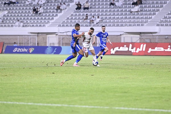 عمرو عبدالفتاح يمر بالكرة من بين لاعبي ااجهراء
