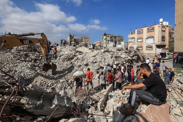 فلسطينيون يتابعون فرق الدفاع المدني خلال بحثها عن جثث ضحايا نتيجة الغارات الاسرائيلية على قطاع غزة ( ا.ف.ب)