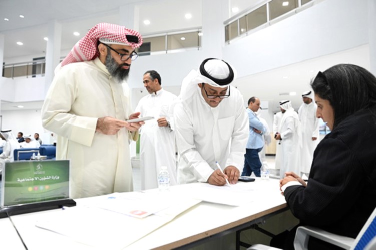 طلال جاسم الخرافي يوقع بكشف أعضاء الجمعية العمومية لإثبات الحضور قبل بدء الاجتماع