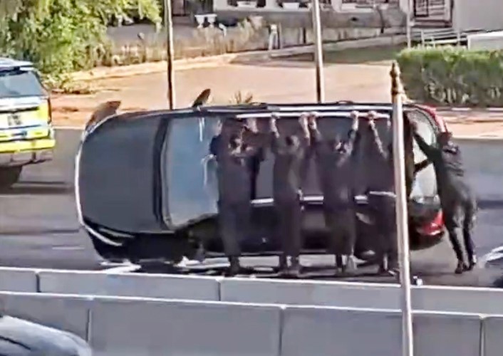 ورجال دوريات المرور لدى إعادة المركبة إلى وضعها