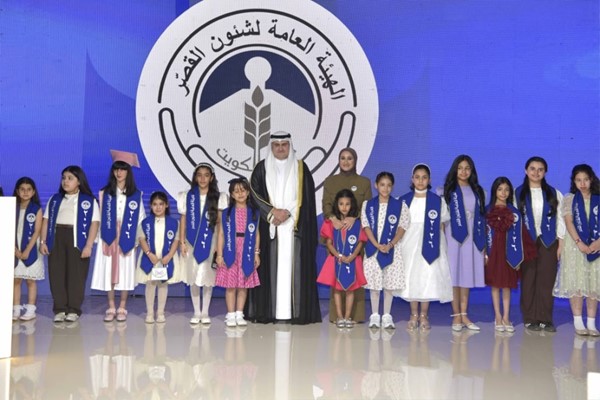  وزير العدل ورئيس مجلس إدارة الهيئة العامة لشؤون القصر المستشار ناصر السميط ومدير عام الهيئة بالتكليف علياء الصقر متوسطين عددا من الطالبات المتفوقات من أبناء الهيئة